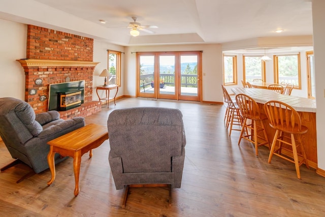10207 N Comanche Dr, Spokane, WA 99208 - living area with ceiling fan, wood finished floors, a fireplace, and a raised ceiling