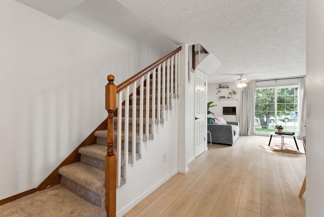 7878 N Wilding Dr # 32, Spokane, WA 99208 - stairway with ceiling fan, a textured ceiling, and wood finished floors