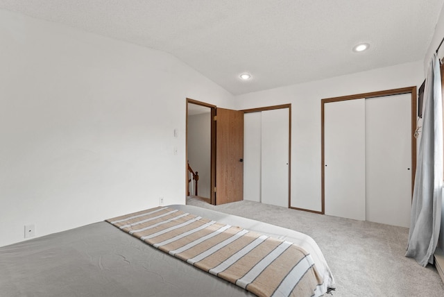 7878 N Wilding Dr # 32, Spokane, WA 99208 - unfurnished bedroom with two closets, carpet, lofted ceiling, and recessed lighting