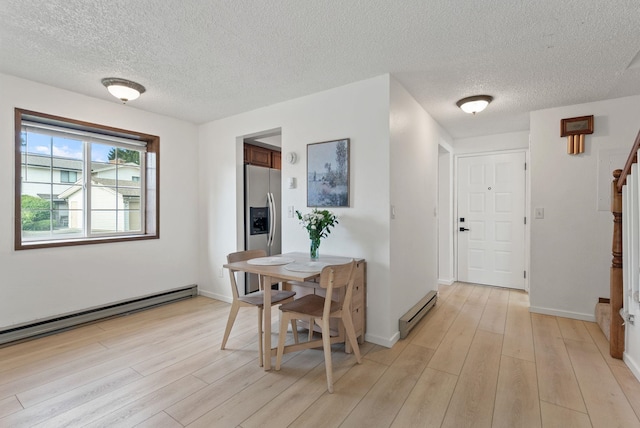 7878 N Wilding Dr # 32, Spokane, WA 99208 - dining area with a textured ceiling, light wood-style flooring, stairs, and a baseboard heating unit