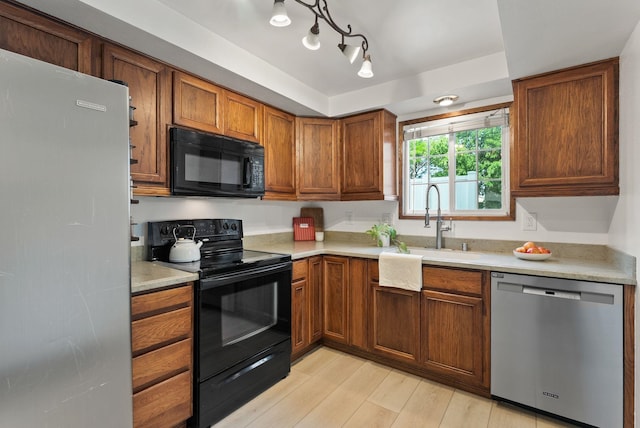7878 N Wilding Dr # 32, Spokane, WA 99208 - kitchen featuring black appliances, light countertops, light wood-type flooring, and brown cabinetry