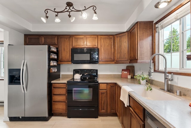 7878 N Wilding Dr # 32, Spokane, WA 99208 - kitchen with black appliances, brown cabinetry, and light countertops