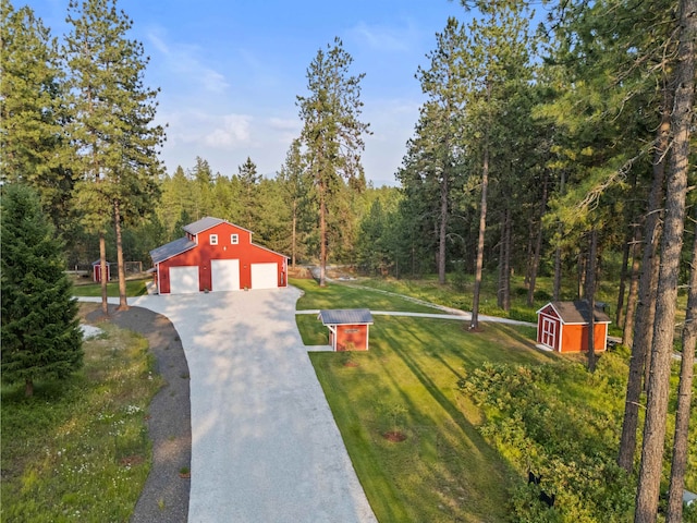 3 W Montgomery Rd, Deer Park, WA 99006 - view of front of property with asphalt driveway, a front lawn, a detached garage, a view of trees, and a storage unit