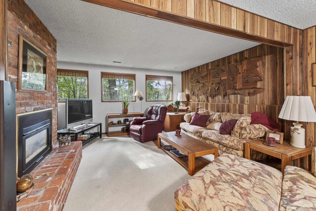 13614 N Minihdoka Trl, Spokane, WA 99208 - living area featuring carpet, wooden walls, a fireplace, a textured ceiling, and ceiling fan