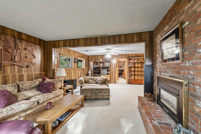 13614 N Minihdoka Trl, Spokane, WA 99208 - carpeted living room with wooden walls, a fireplace, a textured ceiling, and ceiling fan