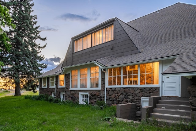 1625 S Hayford Rd, Spokane, WA 99224 - back of house at dusk featuring roof with shingles, stone siding, entry steps, and a yard