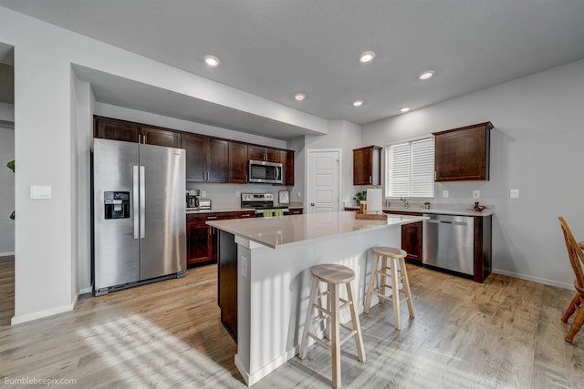 3640 S Clinton Rd, Spokane Valley, WA 99206 - kitchen with stainless steel appliances, light wood-type flooring, a breakfast bar area, light countertops, and recessed lighting