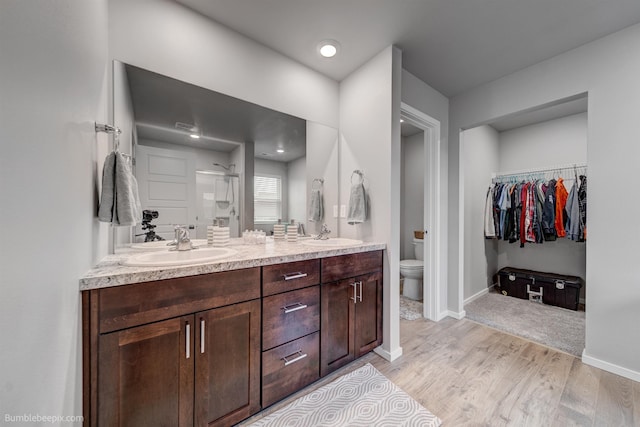 3640 S Clinton Rd, Spokane Valley, WA 99206 - bathroom with double vanity, a shower stall, wood finished floors, and a spacious closet