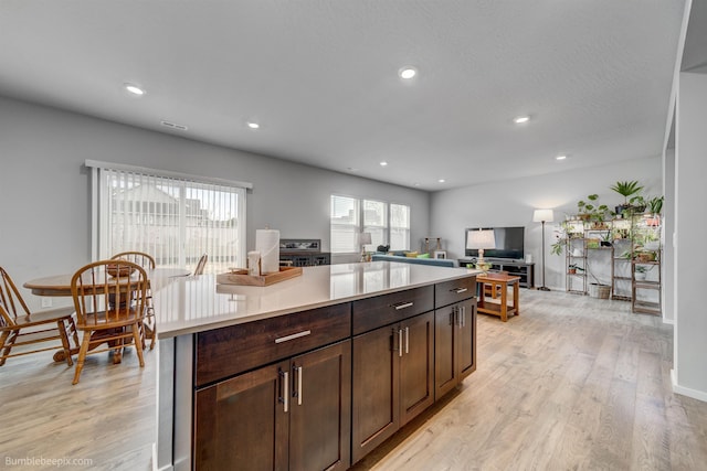 3640 S Clinton Rd, Spokane Valley, WA 99206 - kitchen featuring light countertops, light wood-type flooring, recessed lighting, dark brown cabinetry, and a center island