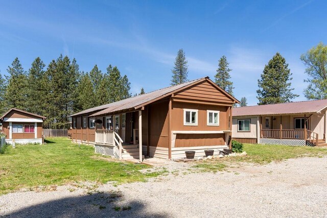 105 E Aspen Ave, Springdale, WA 99173 - view of front of property featuring covered porch, a metal roof, and a front lawn