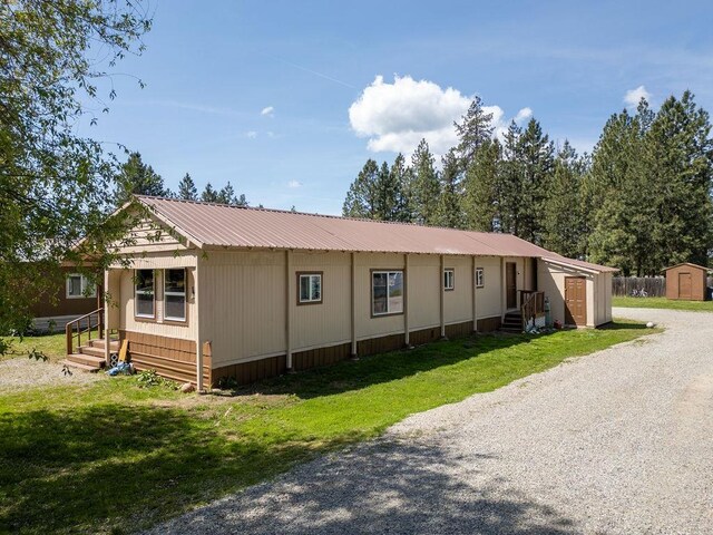 105 E Aspen Ave, Springdale, WA 99173 - manufactured / mobile home with a storage unit, a front yard, a metal roof, and entry steps