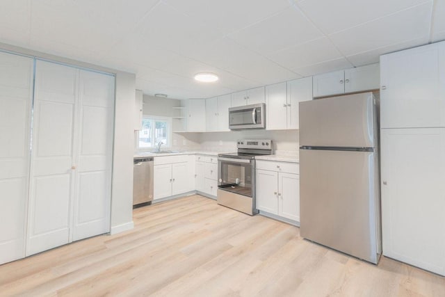 105 E Aspen Ave, Springdale, WA 99173 - kitchen with stainless steel appliances, a drop ceiling, open shelves, light countertops, and light wood finished floors