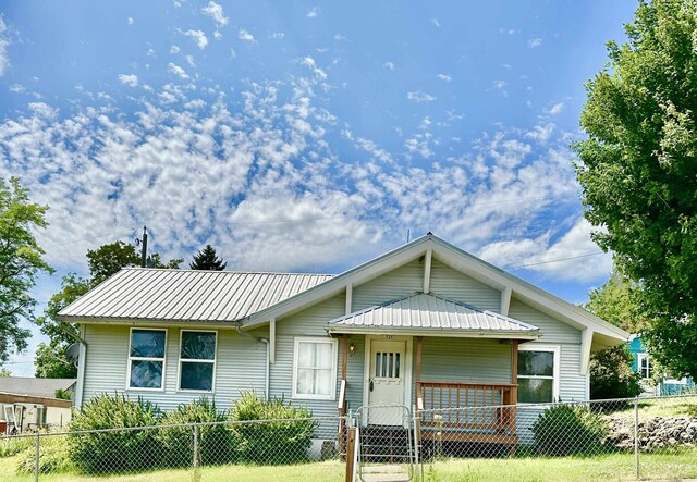 521 N Ramsey St, Tekoa, WA 99033 - view of front of home featuring a metal roof, a fenced front yard, and a gate