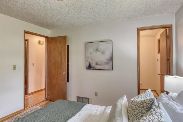 3308 W Kiernan Ave, Spokane, WA 99205 - bedroom featuring a textured ceiling, light wood-style floors, and ensuite bath
