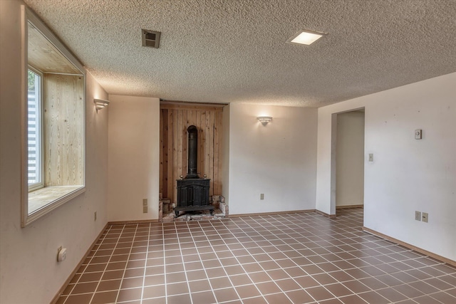 3308 W Kiernan Ave, Spokane, WA 99205 - unfurnished living room with a textured ceiling and a wood stove