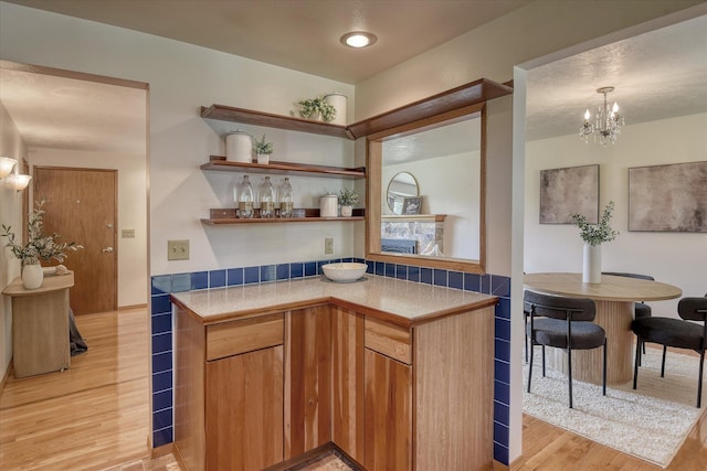 3308 W Kiernan Ave, Spokane, WA 99205 - kitchen with light wood-style flooring, a chandelier, open shelves, and light countertops