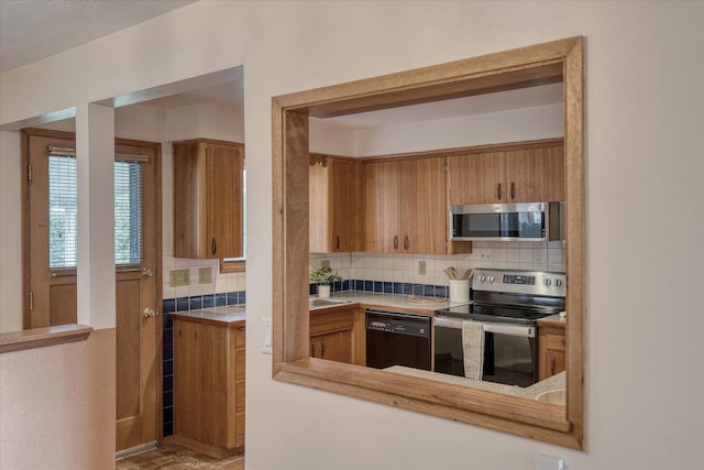3308 W Kiernan Ave, Spokane, WA 99205 - kitchen with stainless steel appliances, backsplash, and brown cabinetry