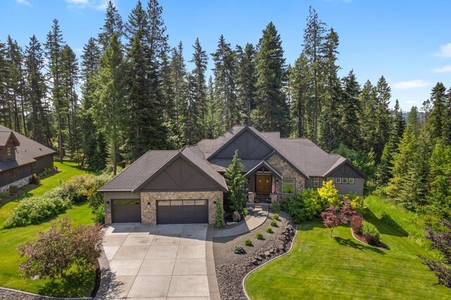 3742 W Cielo View Ct, Coeur D Alene, ID 83814 - view of front of house with an attached garage, driveway, a front lawn, and a wooded view