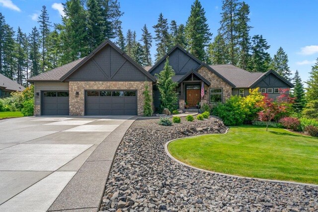 3742 W Cielo View Ct, Coeur D Alene, ID 83814 - craftsman house featuring stone siding, an attached garage, driveway, and a front lawn