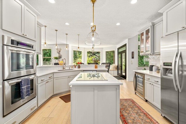 3742 W Cielo View Ct, Coeur D Alene, ID 83814 - kitchen with appliances with stainless steel finishes, beverage cooler, a peninsula, recessed lighting, and backsplash