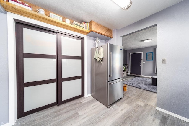 4128 E 22nd Ave, Spokane, WA 99223 - kitchen with freestanding refrigerator, light wood finished floors, and a textured ceiling