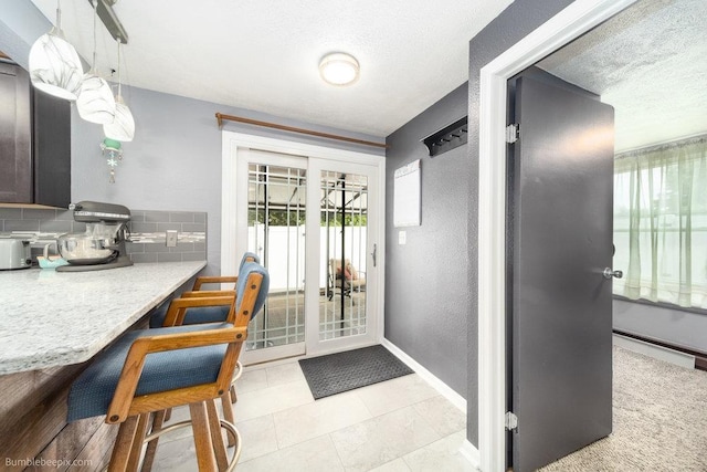 4128 E 22nd Ave, Spokane, WA 99223 - kitchen with tasteful backsplash, a textured wall, light countertops, a textured ceiling, and a kitchen breakfast bar