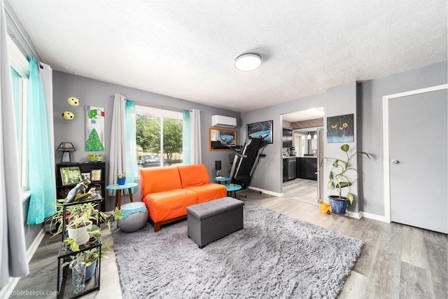 4128 E 22nd Ave, Spokane, WA 99223 - living area with a textured ceiling, wood finished floors, and a wall unit AC