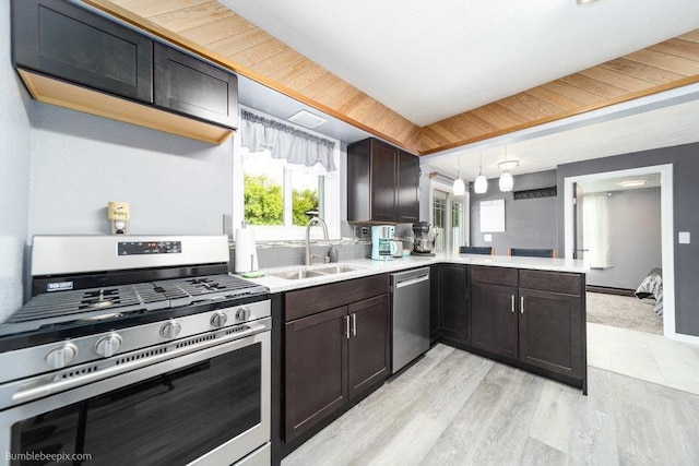 4128 E 22nd Ave, Spokane, WA 99223 - kitchen featuring stainless steel appliances, light countertops, dark brown cabinets, a peninsula, and light wood-style flooring