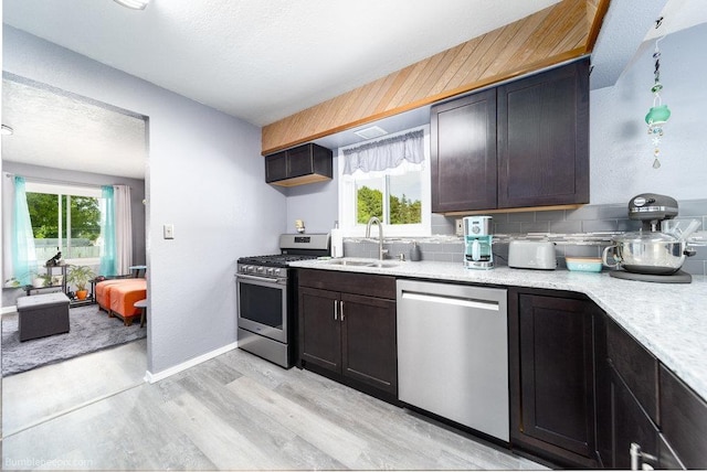 4128 E 22nd Ave, Spokane, WA 99223 - kitchen with appliances with stainless steel finishes, light wood-style flooring, dark brown cabinetry, and a textured ceiling