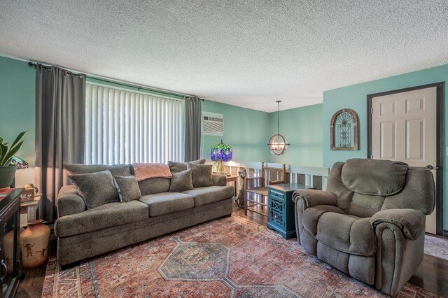 6821 N Hamilton St Unit 1, Spokane, WA 99208 - living room with a chandelier, wood finished floors, a textured ceiling, and a wall mounted AC