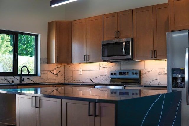 11208 E Rimrock Ln, Spokane Valley, WA 99206 - kitchen featuring appliances with stainless steel finishes, dark countertops, decorative backsplash, and a center island