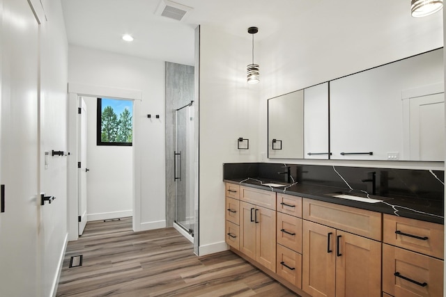 11208 E Rimrock Ln, Spokane Valley, WA 99206 - full bathroom featuring double vanity, a shower stall, wood finished floors, and recessed lighting