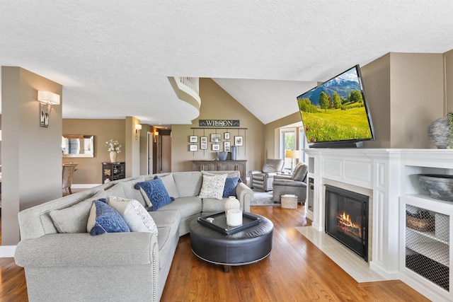 2804 W Johannsen Rd, Spokane, WA 99208 - living room with wood finished floors, a fireplace with flush hearth, a textured ceiling, and vaulted ceiling