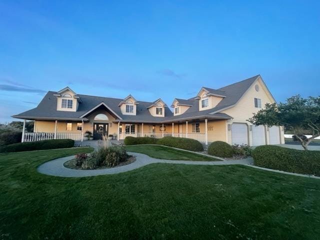 2804 W Johannsen Rd, Spokane, WA 99208 - new england style home with covered porch, a front lawn, and a garage