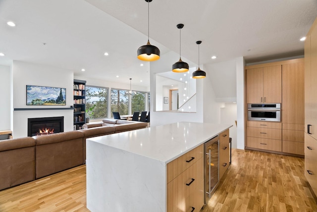 2435 W Riverside Ave, Spokane, WA 99201 - kitchen with light wood finished floors, wine cooler, modern cabinets, stainless steel oven, and recessed lighting