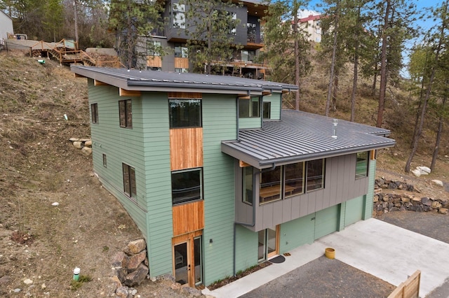 2435 W Riverside Ave, Spokane, WA 99201 - rear view of property with asphalt driveway, an attached garage, a metal roof, and a standing seam roof