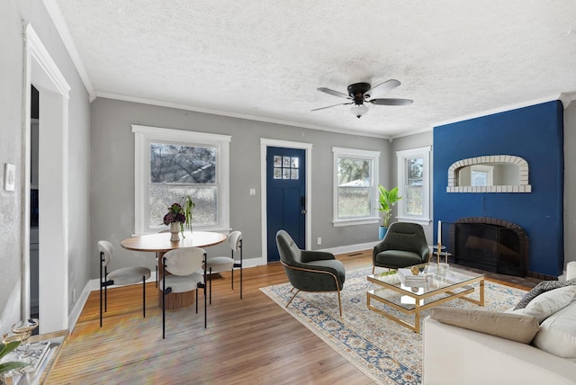 107 E 29th Ave, Spokane, WA 99203 - living area with light wood-style flooring, ornamental molding, ceiling fan, a textured ceiling, and a fireplace