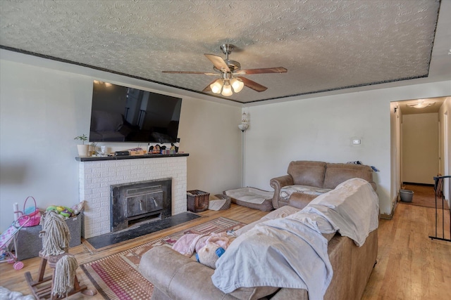 2804 E Marshall Ave, Spokane, WA 99207 - living room featuring a textured ceiling, a ceiling fan, wood finished floors, and a fireplace