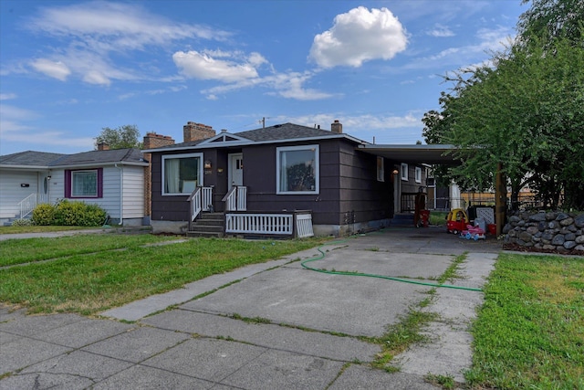 2804 E Marshall Ave, Spokane, WA 99207 - bungalow-style home with driveway, a carport, a front lawn, and a chimney