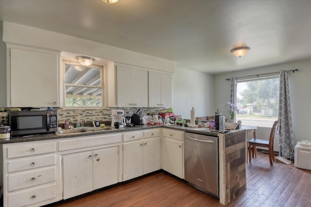 2804 E Marshall Ave, Spokane, WA 99207 - kitchen featuring stainless steel appliances, a peninsula, dark countertops, and wood finished floors