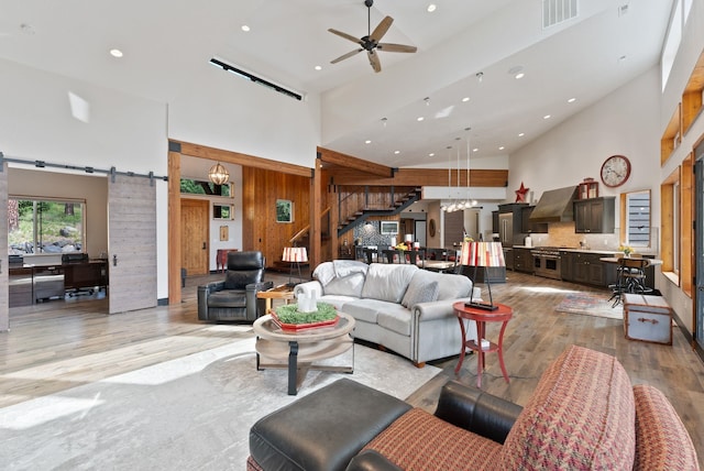 25204 N Lords Ln, Chattaroy, WA 99003 - living room featuring a high ceiling, a barn door, stairs, light wood-style flooring, and recessed lighting