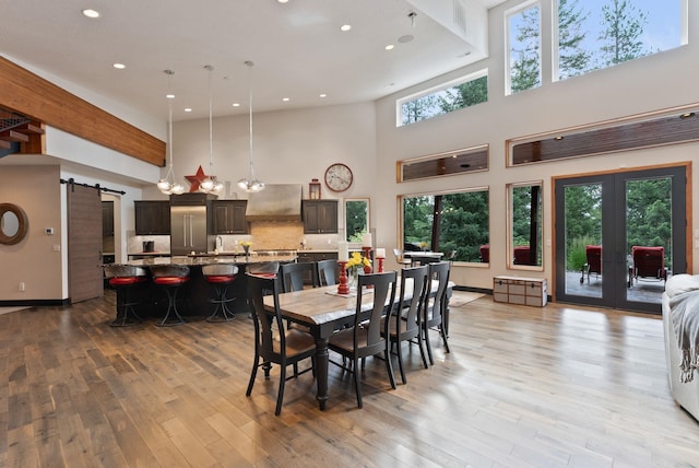 25204 N Lords Ln, Chattaroy, WA 99003 - dining room with a high ceiling, light wood-style flooring, recessed lighting, a barn door, and french doors