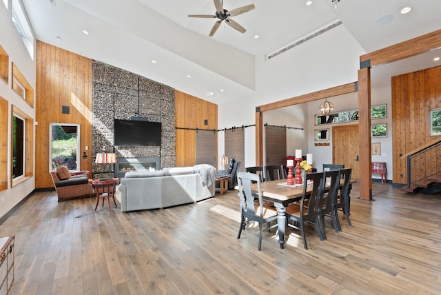 25204 N Lords Ln, Chattaroy, WA 99003 - dining room with a towering ceiling, a barn door, wooden walls, ceiling fan, and recessed lighting