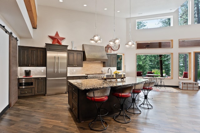25204 N Lords Ln, Chattaroy, WA 99003 - kitchen featuring built in fridge, custom exhaust hood, a towering ceiling, dark wood-style floors, and a breakfast bar