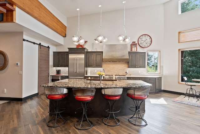 25204 N Lords Ln, Chattaroy, WA 99003 - kitchen with a towering ceiling, built in refrigerator, custom exhaust hood, a barn door, and a kitchen breakfast bar