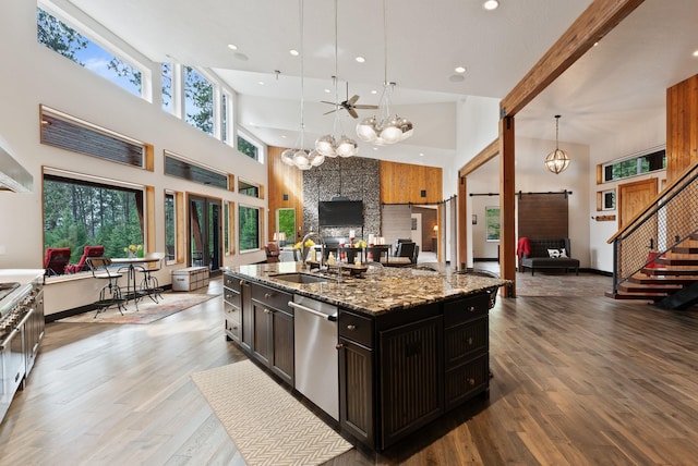 25204 N Lords Ln, Chattaroy, WA 99003 - kitchen with stainless steel dishwasher, open floor plan, a towering ceiling, a chandelier, and stone counters