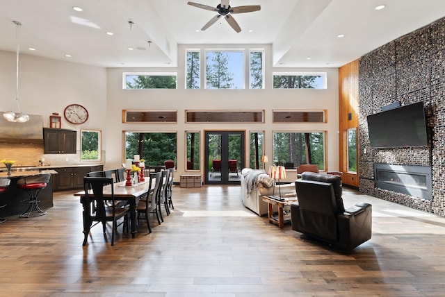 25204 N Lords Ln, Chattaroy, WA 99003 - dining space featuring a towering ceiling, light wood-style flooring, a tile fireplace, a ceiling fan, and recessed lighting