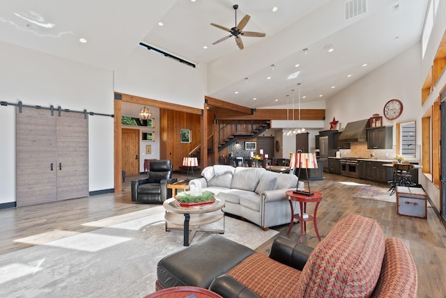 25204 N Lords Ln, Chattaroy, WA 99003 - living area featuring a towering ceiling, hardwood / wood-style flooring, stairway, a barn door, and recessed lighting