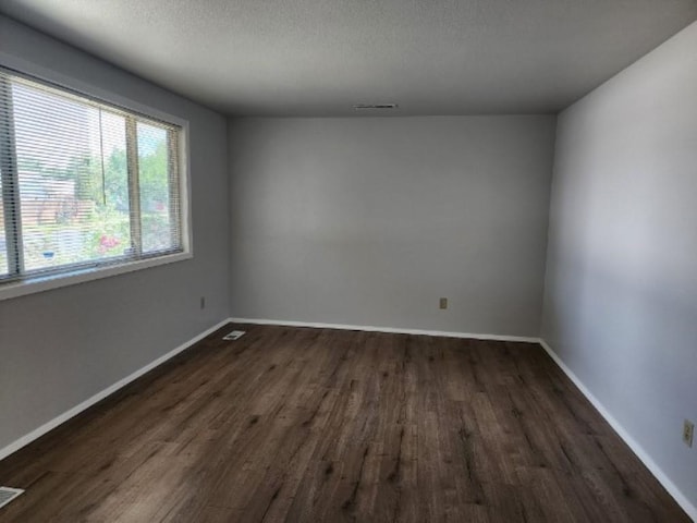 704 E Beacon Ave, Spokane, WA 99208 - spare room featuring dark wood-type flooring and a textured ceiling