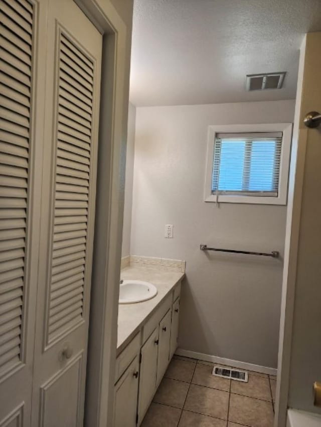 704 E Beacon Ave, Spokane, WA 99208 - full bath with a closet, vanity, tile patterned flooring, and a textured ceiling